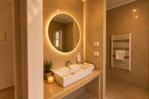 a bathroom with a white sink and a mirror at Fenisien Boutique Rooms in Contursi