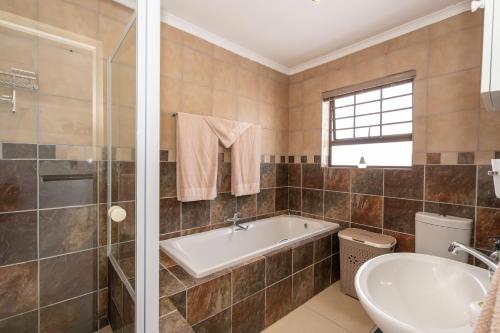 a bathroom with a tub and a sink at Where Time Stops in Langebaan