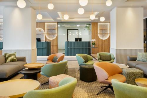 a lobby with couches and chairs and tables at Barceló Dresden Newa in Dresden
