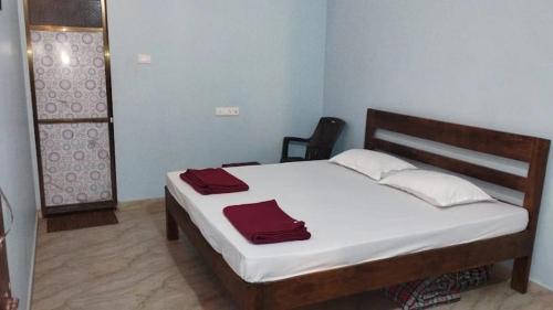 a bedroom with a bed with red towels on it at Sanvi Resort Malvan in Malvan