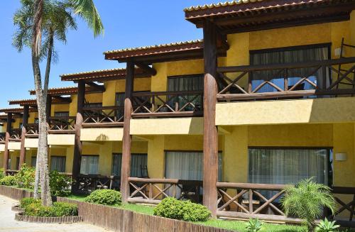 a yellow building with palm trees in front of it at Iara Beach Hotel Boutique in Salvador