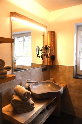 a bathroom with a stone sink and a mirror at Landhaus Theresia in Maria Alm am Steinernen Meer