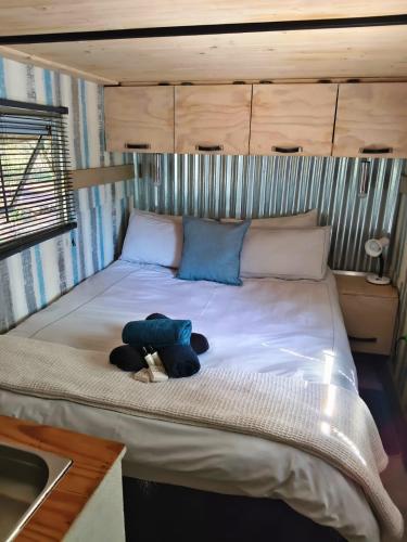 a large bed with a teddy bear laying on it at Romantic Hot Tub Retreat - Ndlovu 33 Tiny Home, Big 5 reserve in Klipdrift