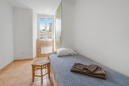 a bedroom with a bed with towels and a chair at Boni in Saint-Julien-Molin-Molette