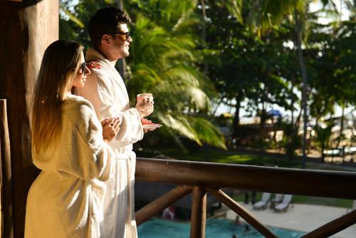 a man and a woman standing next to a fence at Iara Beach Hotel Boutique in Salvador