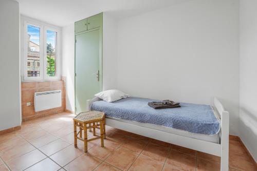 a bedroom with a bed and a chair and a window at Boni in Saint-Julien-Molin-Molette