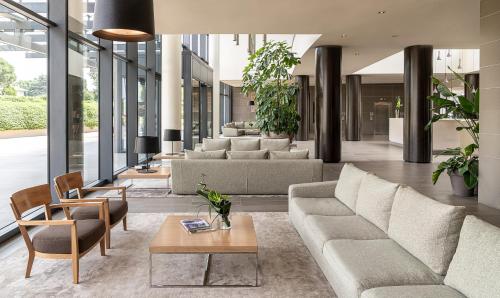 a living room with couches and tables in a building at MOVE Hotels Venezia Nord in Mogliano Veneto