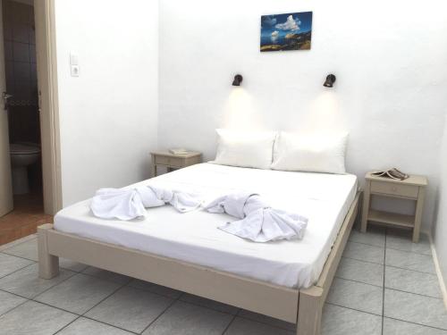 ein Schlafzimmer mit einem Bett mit weißen Laken und Kissen in der Unterkunft Pavlosx2 in Folegandros Chora