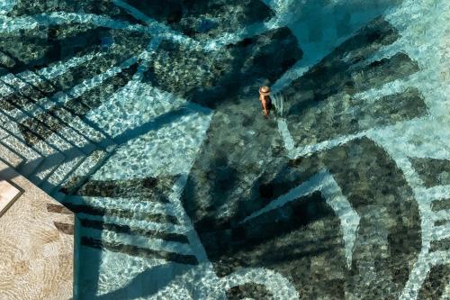 an overhead view of a man in the water at BLESS Ibiza The Site - New Opening 2026 in Playa d'en Bossa