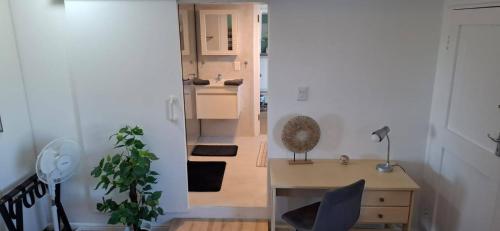 a room with a desk and a table and a kitchen at Agape Apartments in Somerset West
