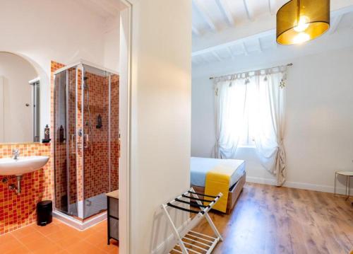 a bedroom with a bed and a bathroom with a sink at B&B Residenza Ricasoli Grosseto centro storico in Grosseto