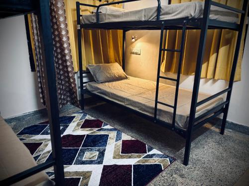 a couple of bunk beds in a room with a rug at Deodar Commune in Visakhapatnam