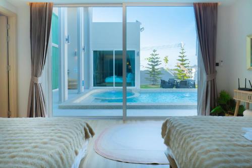 a bedroom with two beds and a swimming pool at Luma & Malta PoolVilla Cha-am in Sathani Nong Ta Phot