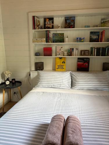 a bedroom with a large bed with book shelves at The Bloom Farm Cottage in Carrajung South