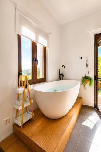 a large white tub in a bathroom with a window at Villa Ikaros in Agia Triada