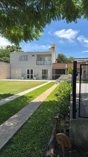a modern house with a grassy yard at Hospedaje Buena Vibra in San Nicolás de los Arroyos