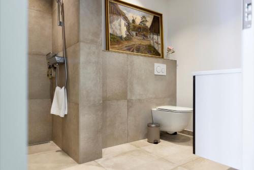 a bathroom with a toilet and a painting on the wall at Westergaards Hotel in Videbæk