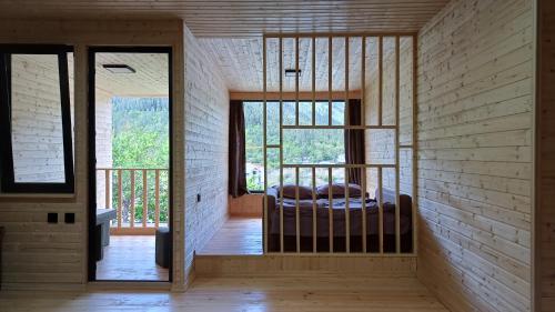 a bedroom with a bed in the middle of a room at Eco Cottage Rose in Borjomi