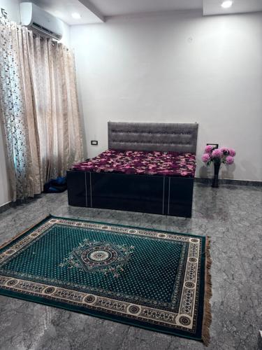 a bedroom with a bed and a rug at NaPrer Homes in Dehradun