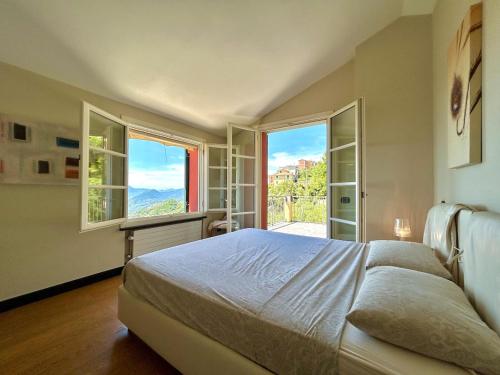 a bedroom with a large bed and large windows at COGO, Premium Private Villa Vista Mare in Cogorno