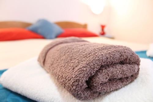 a brown towel sitting on top of a bed at Guest House Tomanovic in Herceg-Novi