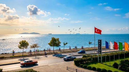 a parking lot next to the ocean with cars and people at Kalyon Hotel Istanbul in Istanbul
