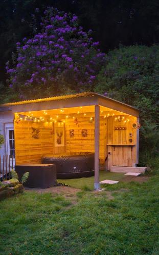 a small building with lights on it in a yard at Ker Adèle, longère cosy au cœur d'un bois in Ploërdut