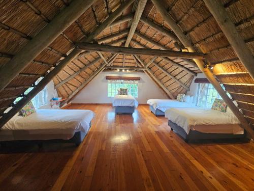a attic bedroom with three beds in a room at Pearse Farm Stay in Howick