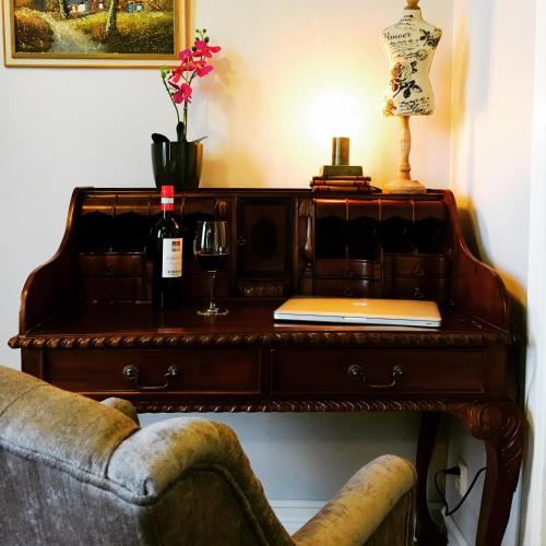 a table with a bottle of wine and a wine glass at Grenna Hotell in Gränna