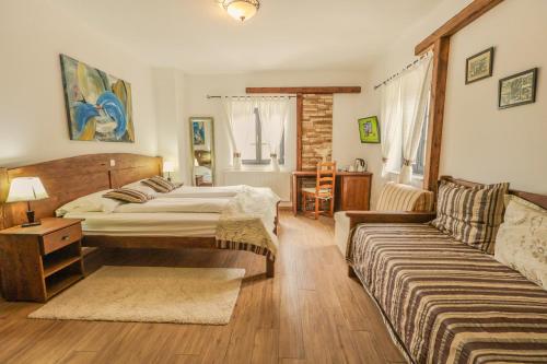a bedroom with two beds and a couch at Etno Garden Exclusive in Plitvička Jezera
