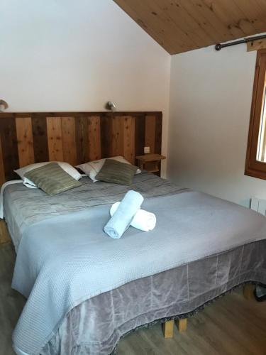 a bedroom with a large bed with two towels on it at Ferme de la Clarée in Névache