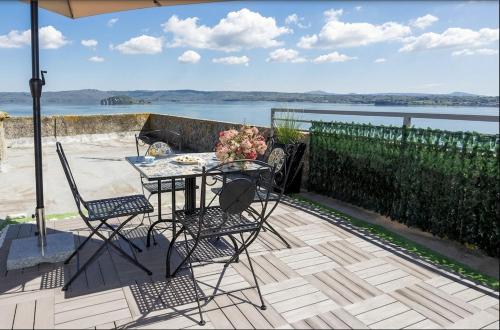 a table and chairs on a patio with a view of the water at La Terrazza sul Lago in Capodimonte