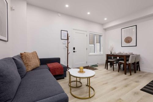 a living room with a blue couch and a table at Newly Built Suite-West Coquitlam in Coquitlam