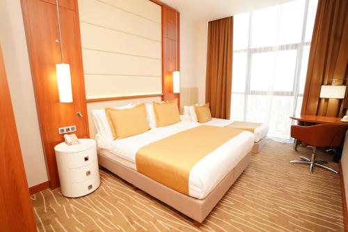 a hotel room with a bed and a desk at Grand Bellagio Hotel Batumi in Batumi