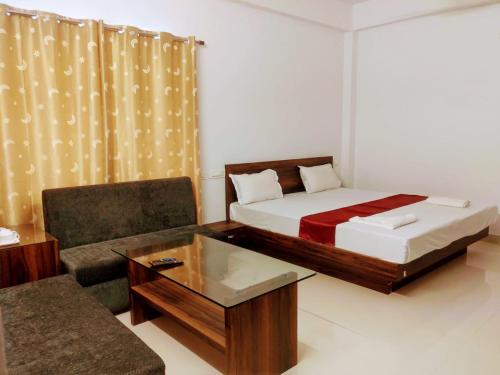 a room with a bed and a chair and a couch at Boroli in Shaugaon
