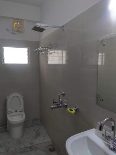 a bathroom with a white toilet and a sink at Boroli in Shaugaon