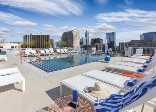 a rooftop deck with lounge chairs and a swimming pool at Austin Resort Studio Apartment in Austin