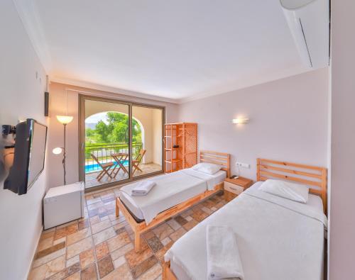 a bedroom with two beds and a balcony at BURÇ HOTEL in Dalaman