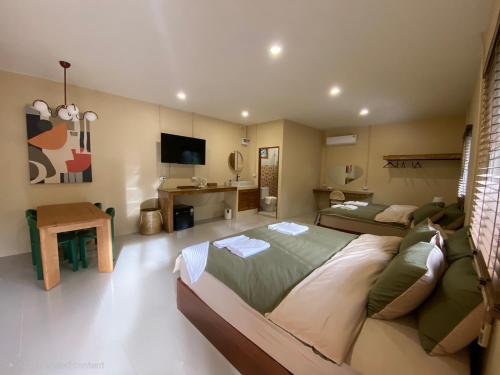 a large bedroom with two beds and a television at Koh Tao Stay in Ko Tao