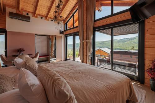 a bedroom with a large bed and large windows at Bükk Hill Garden in Miskolc