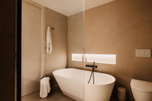 a bathroom with a white tub in the corner at B Kaprun in Kaprun