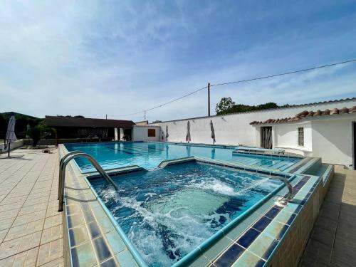 a large swimming pool with blue water at VILLA PRAXEDES con piscina a Nettuno in Nettuno