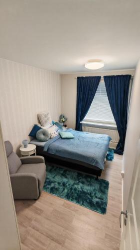 a bedroom with a bed and a couch and a window at SEA - 3 Bedrooms in Kristinestad