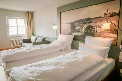 a hotel room with two beds and a couch at Bodensee-Schloss Maurach in Uhldingen-Mühlhofen