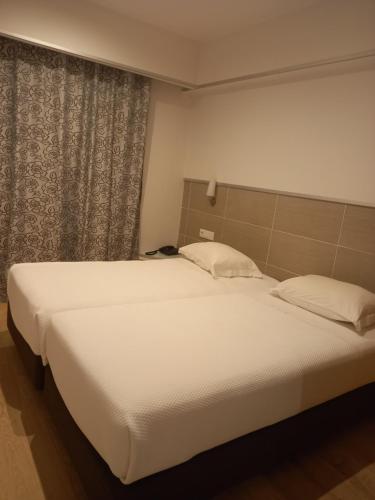 a bedroom with a large white bed and a window at Guesthouse Bocage in Setúbal