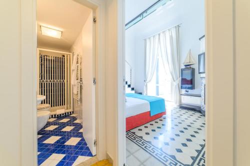 a hotel room with a bed and a bathroom at Amalfi Gallery Room & Suite in Amalfi