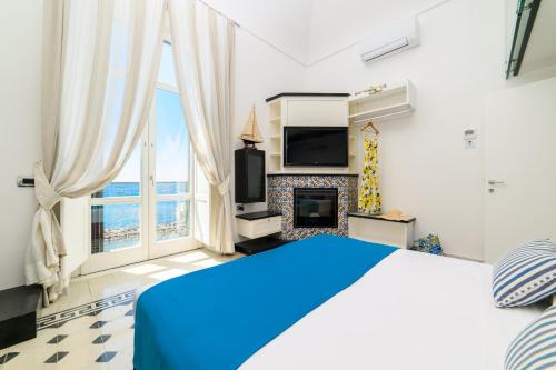 a bedroom with a blue bed and a fireplace at Amalfi Gallery Room & Suite in Amalfi