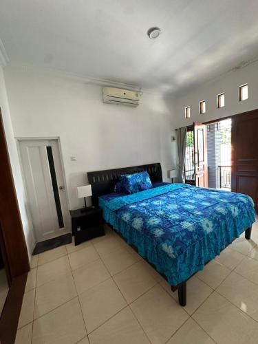 a bedroom with a bed with a blue comforter at waterspring home in Banyuwangi