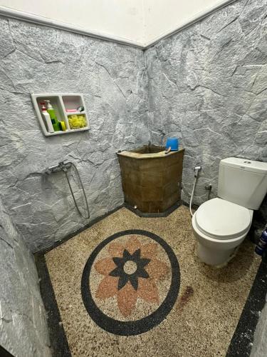 a small bathroom with a toilet and a rug at waterspring home in Banyuwangi