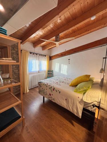 a bedroom with a bed in a room with wooden ceilings at Ca La Martona in Rubio de Dalt